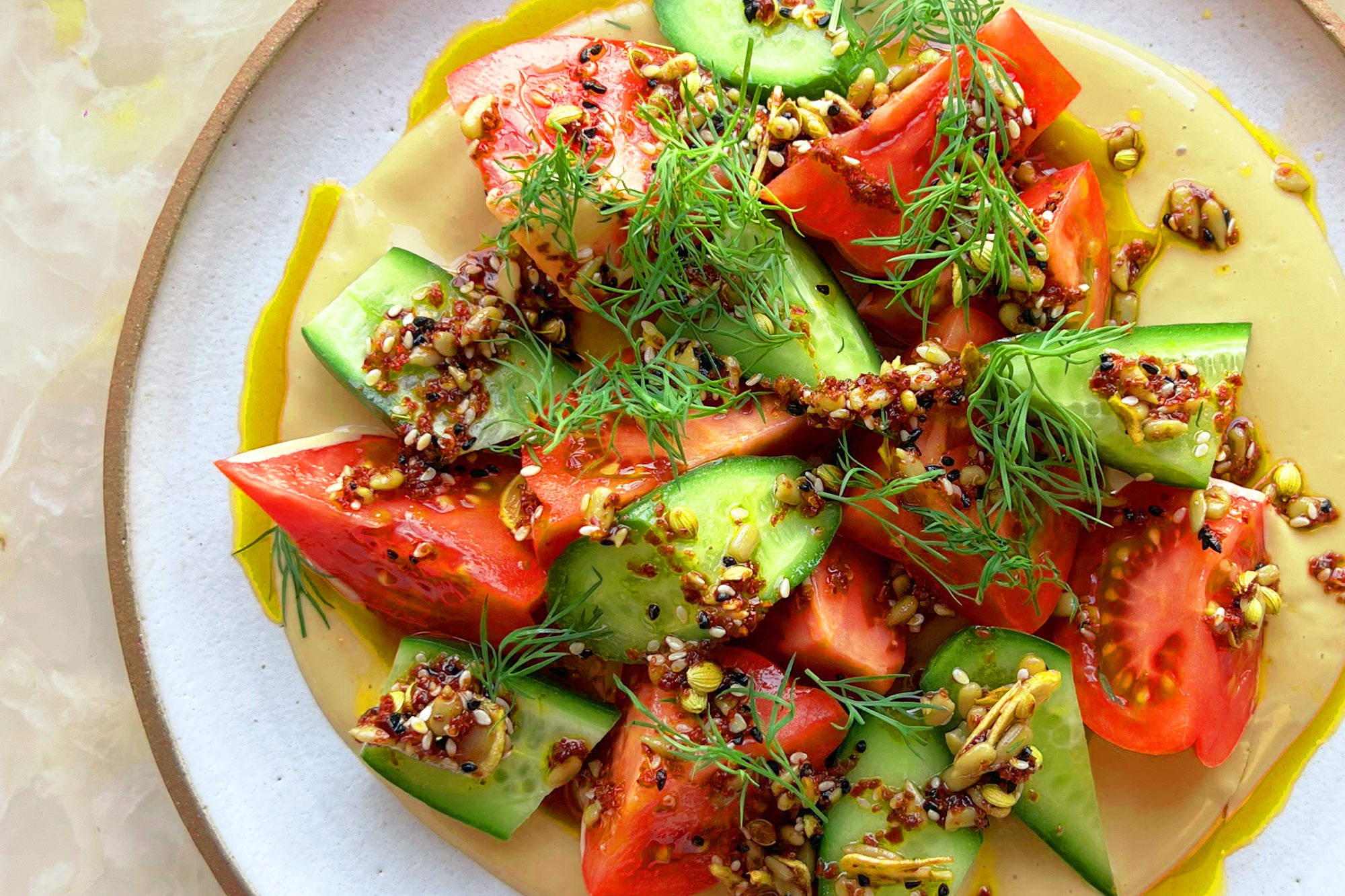 Tomato and cucumber salad with tahini and spicy dukkah oil
