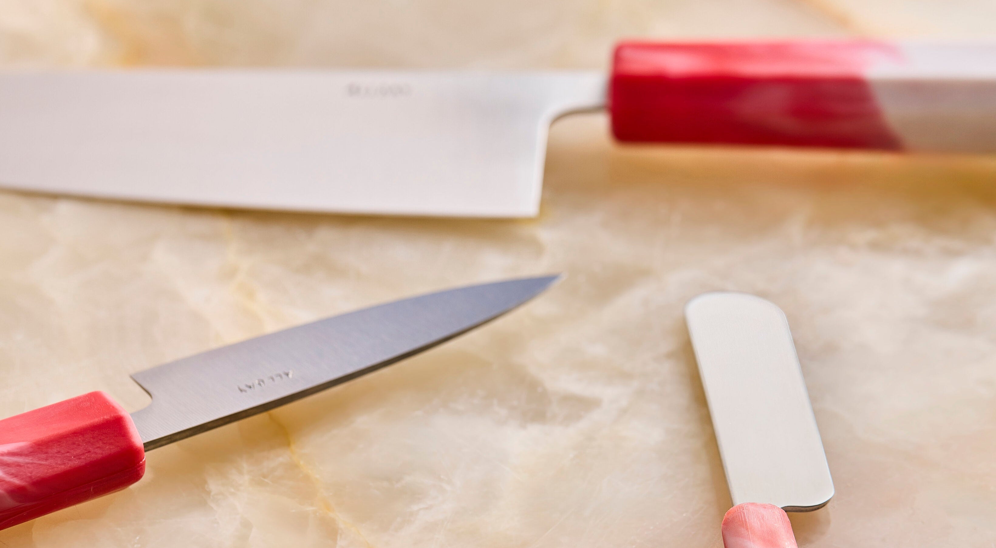 three knives on a marble surface