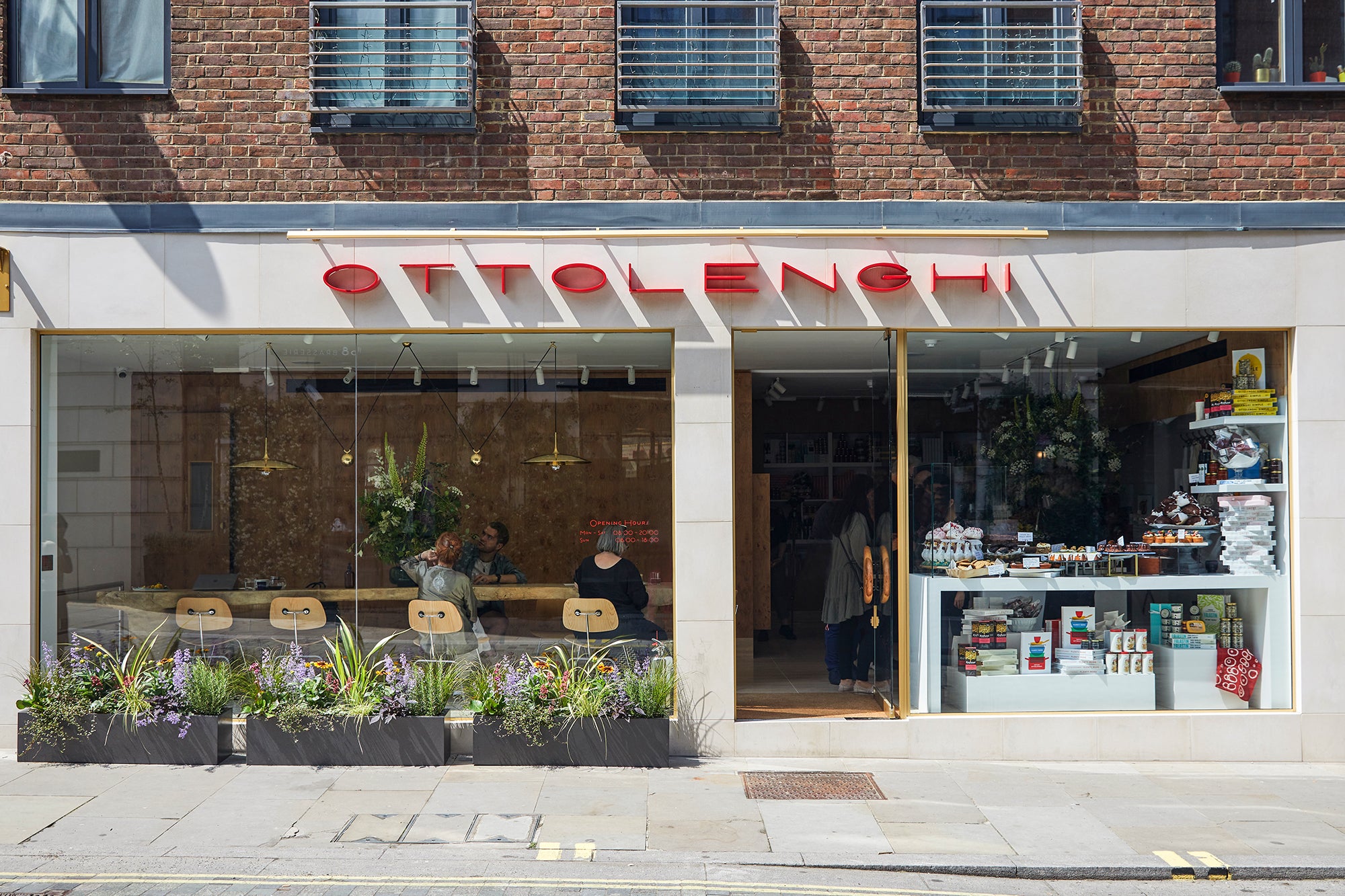 Store front with guests and produce visible through floor to ceiling windows