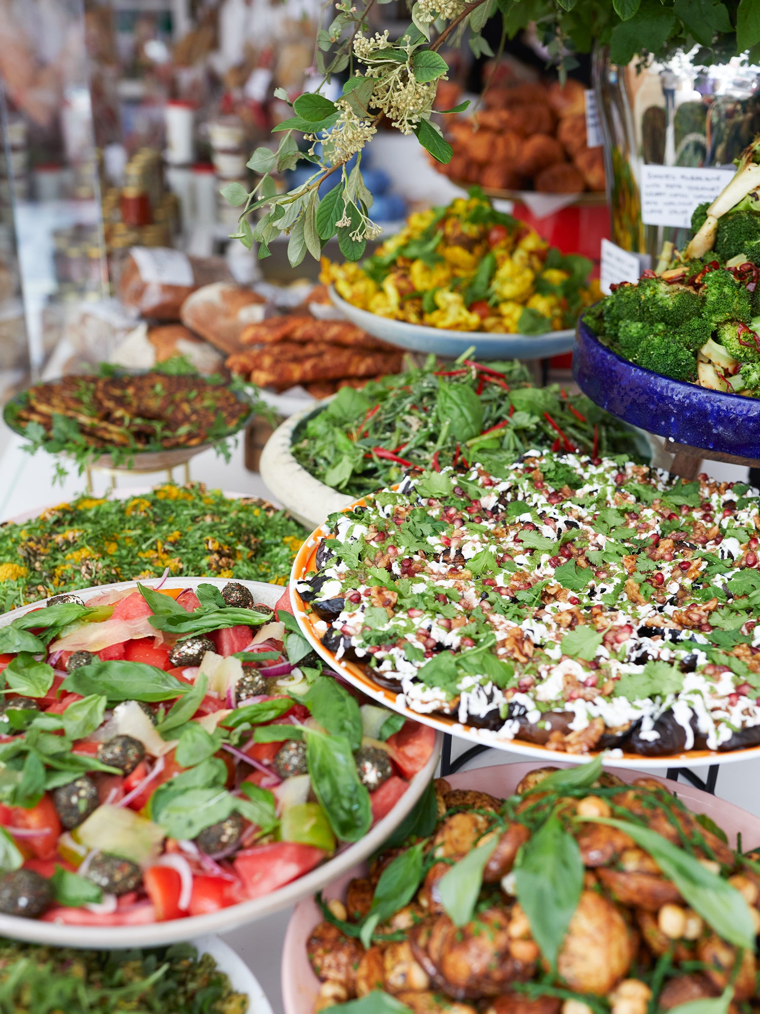 Salad display. Platters of: aubergine with yoghurt and parsley, tomatoes with basil, potatoes, caulilfower