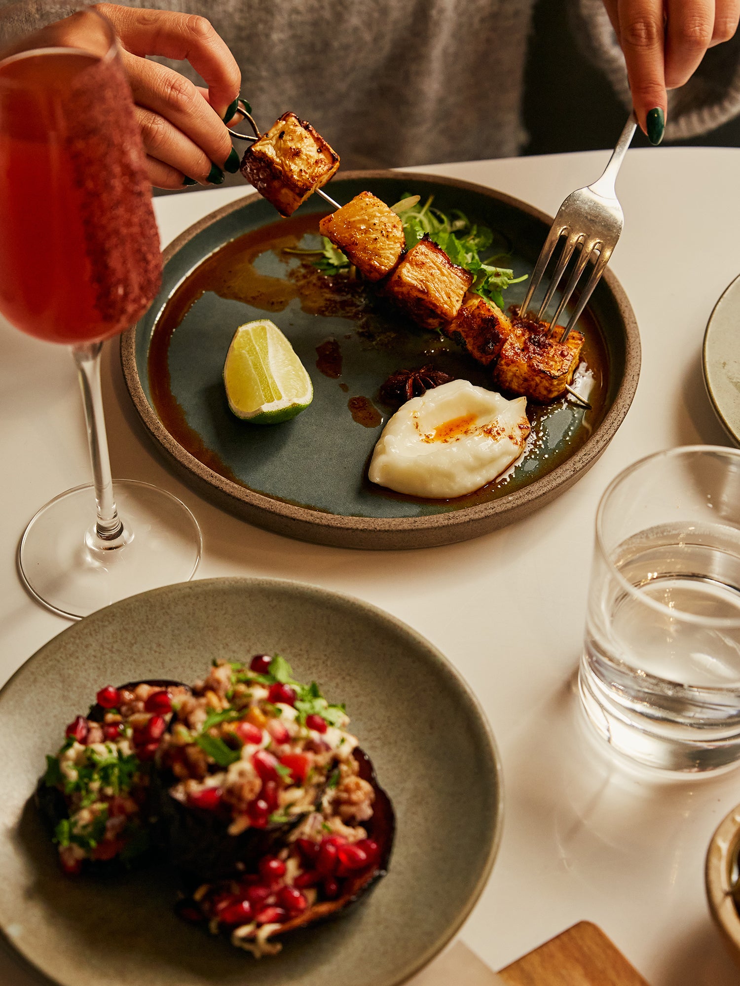 Roasted celeriac skewer with toum, aubergine with pomegranate seeds, sumac French 75 cocktail